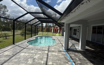 Modern pool patio design with paver flooring, screened enclosure, and inviting swimming pool, enhancing outdoor space aesthetics for homeowners.