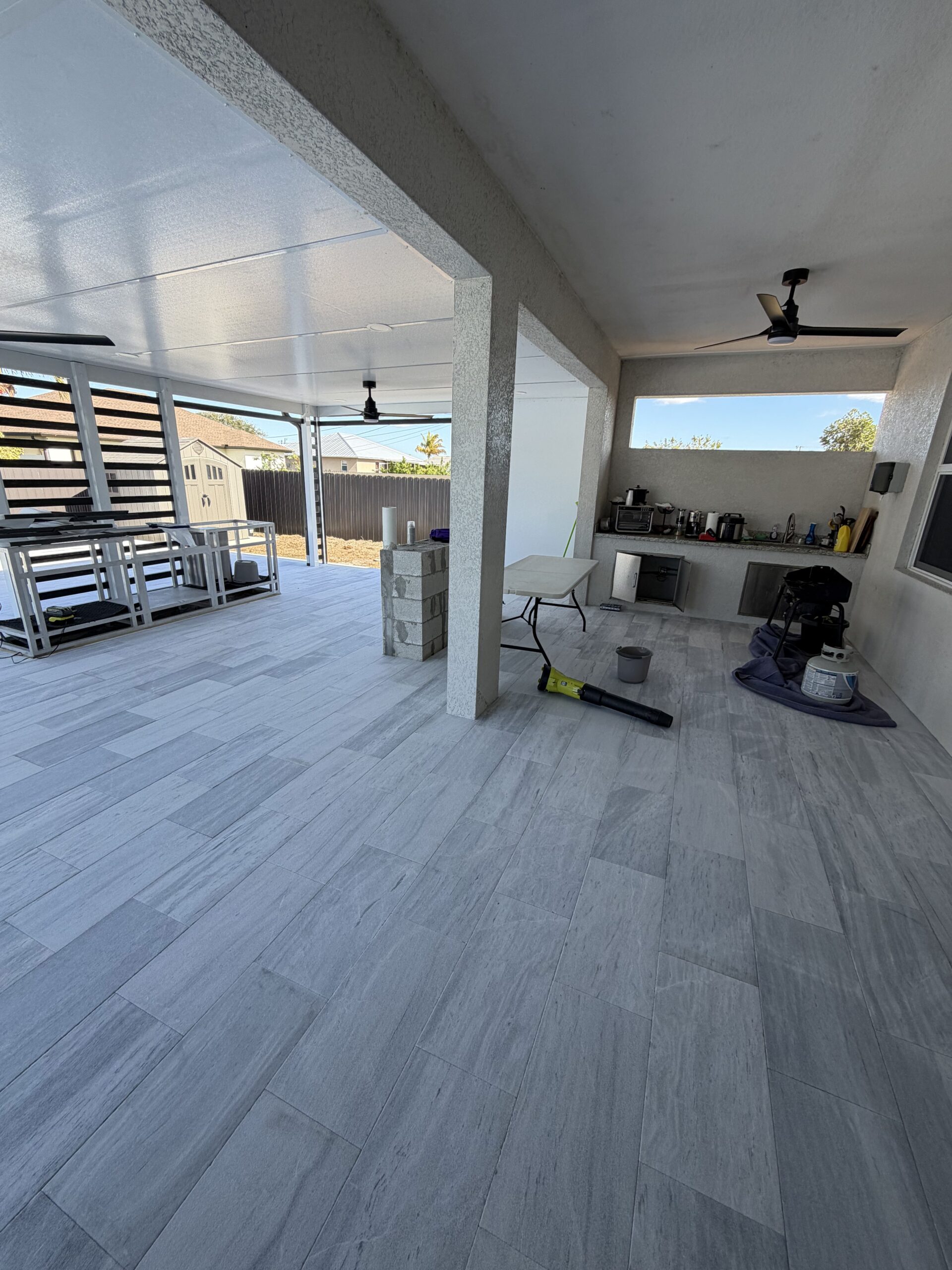 IMG_2076 Paver installation in a modern outdoor living space featuring light gray tiles, showcasing craftsmanship by Elite Pavers Solutions in Southwest Florida.